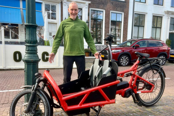 A cyclist poses with a Reise and Muller cargo bike