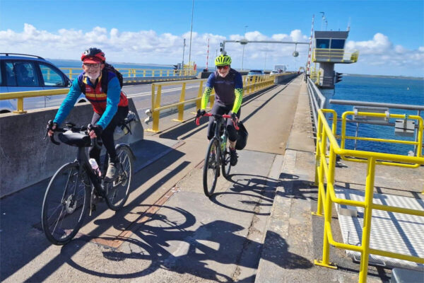 Two riders reach the north side of Zeelandbrug with the cycle path behind them