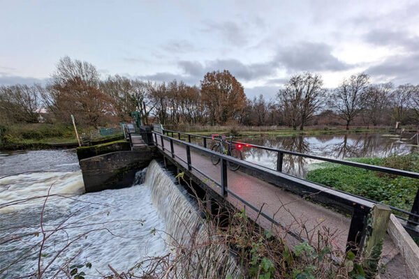 Cannondale Topstone rests on the weir at Ripley on the Wey Navigation with a huge flow of water beneath